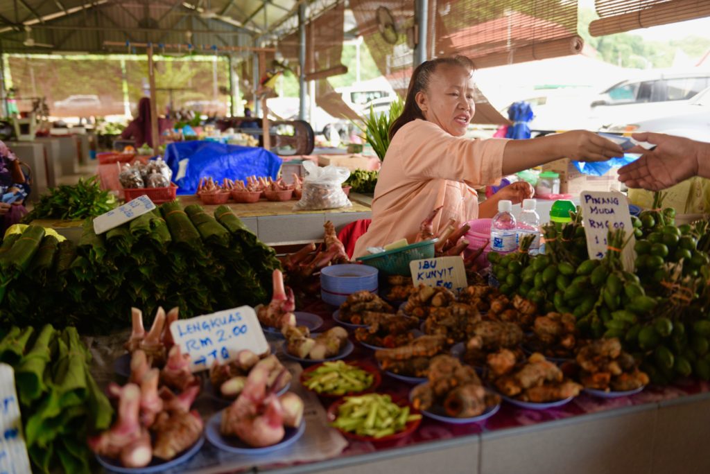 Malaysian woman sells vegetables at a local market in Miri, Sarawak, Borneo